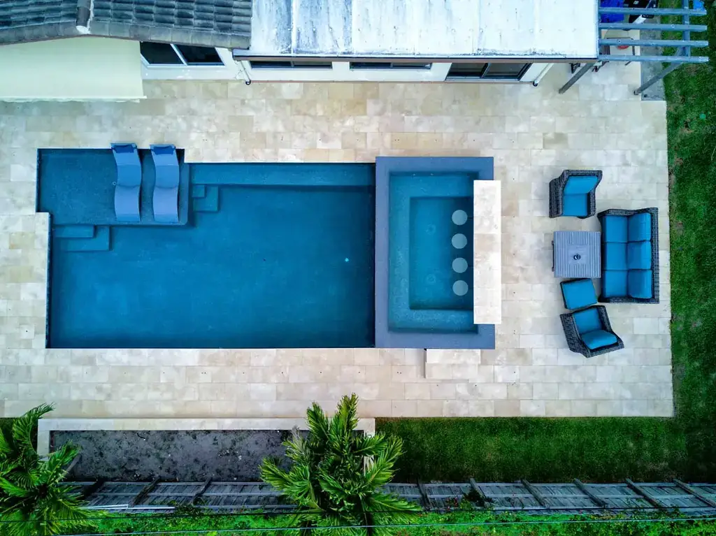 Overhead view of a rectangular pool with a spa and wall mounted water spouts
