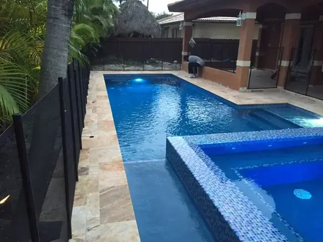 Rectangular pool with a raised spa lit at dusk